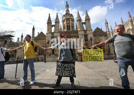 Cambridge, Großbritannien. September 2021. Demonstranten halten sich in einer Kette die Hände, während sich die Truther vor dem Kings College in Cambridge treffen, um Lärm zu machen.Halten Sie die Hände in einer Reihe und zeigen Sie den Menschen, dass sie „wach“ sind, während sie gegen Impfpass und Impfung für Kinder demonstrieren. Die Veranstaltung findet in Städten und Städten in ganz Großbritannien statt. Für den Zugang zu überfüllten Orten wie Nachtclubs und Sportveranstaltungen werden Ende September 2021 Impfpass benötigt. Kredit: SOPA Images Limited/Alamy Live Nachrichten Stockfoto