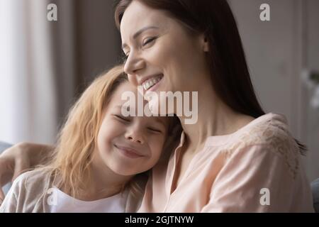 Liebevoll fürsorgliche junge Mutter umarmt niedlichen kleinen Kind Tochter. Stockfoto