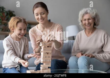 Fröhliche drei verschiedene Generationen weibliche Familie spielen Brettspiel. Stockfoto