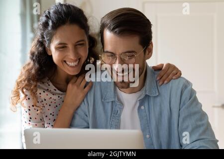 Glückliche Frau und Ehemann beim Blick auf den Laptop-Bildschirm Stockfoto