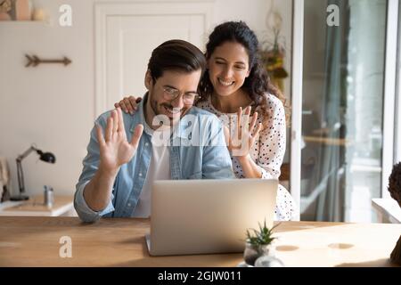Ein Paar führt einen Videoanruf mit einem Laptop durch und spricht mit Verwandten aus der Ferne Stockfoto