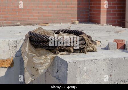 Nahaufnahme einer Spule aus Stahlseil in Fett. Dicker verdrehter Stahl Stockfoto