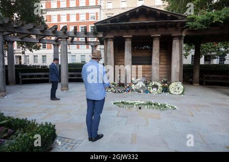 London, Großbritannien. September 2021. Besucher, die während der Gedenkfeier Tribut zollen.der 20. Jahrestag des Angriffs von 9/11 in New York City, der zu 2996 Todesfällen geführt hatte. Das London Memorial wurde am Grosvenor Square eingerichtet, um an die Opfer zu erinnern, die bei dem von der islamischen Extremistengruppe al-Qaida koordinierten Terroranschlag ums Leben kamen. Blumen, Karten und Kerzen wurden im Garten aufgestellt, während Besucher Tribut zollen. (Foto von Belinda Jiao/SOPA Images/Sipa USA) Quelle: SIPA USA/Alamy Live News Stockfoto