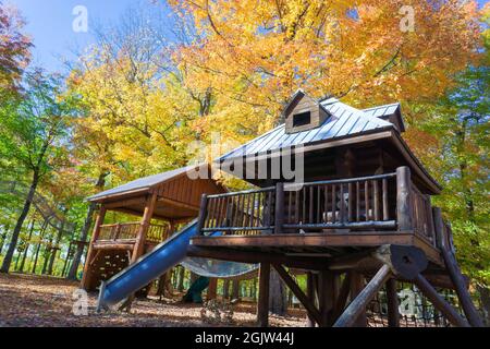 Eine malerische Aussicht auf Holzgebäude in einem Wald, umgeben von farbenfroher Natur im Herbst Stockfoto