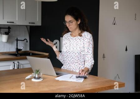Die junge Frau berechnet die persönlichen Finanzen fühlt sich ratlos an Stockfoto