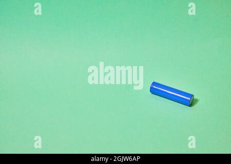 Blaue 18650-Batterie auf grünem Hintergrund. Stockfoto