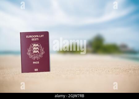 Estnischer Reisepass im Sand am Strand des Meeres. Urlaub für Flitterwochen auf den paradiesischen Inseln Stockfoto