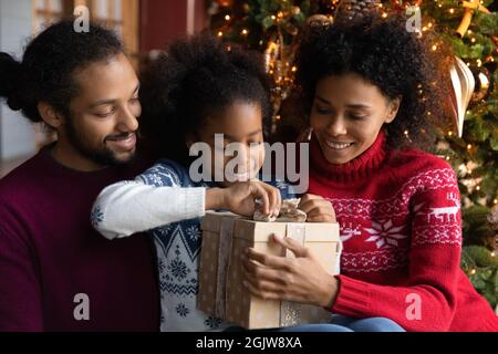 Aufgeregte afroamerikanische Familie mit Kindern öffnen Weihnachtsgeschenke Stockfoto