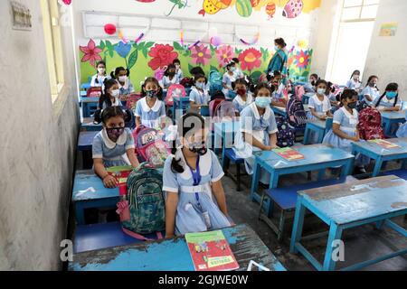 Dhaka, Bangladesch. September 2021. Bangladesch geht mitten in der Pandemie Covid-19 wieder in die Schule. Die Schulbehörden begrüßten die Schüler in den Klassenzimmern, nachdem sie aufgrund der Pandemie von Covid-19 fast eineinhalb Jahre lang geschlossen worden waren. Schüler und Lehrer trugen Masken, benutzten Händedesinfektionsmittel und hielten alle Sicherheitsregeln ein, als sie heute Morgen in die Klassenzimmer gingen. Dhaka, Bangladesch, 12. September 2021. Foto von Habibur Rahman/ABACAPRESS.COM Quelle: Abaca Press/Alamy Live News Stockfoto