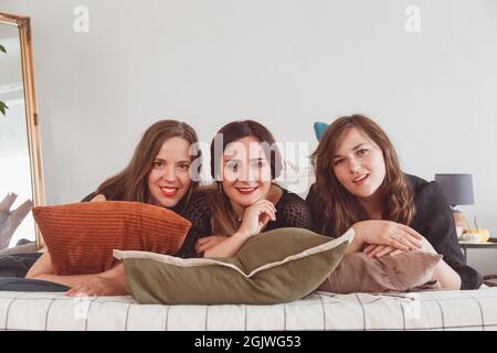 Pyjama-Party, Frauen liegen auf dem Bett, Unterhaltungskonzept. Stockfoto