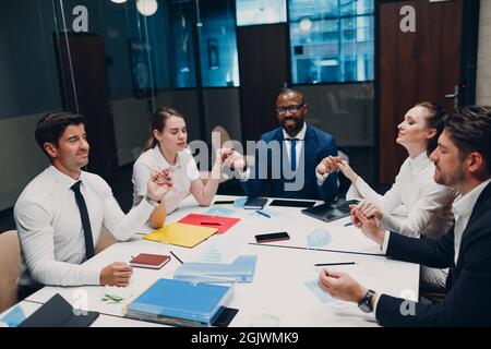 Das Team von Geschäftsleuten meditiert und hält sich nach dem Büromeeting die Hände. Business People Group Konferenz Diskussion Meditationskonzept Stockfoto