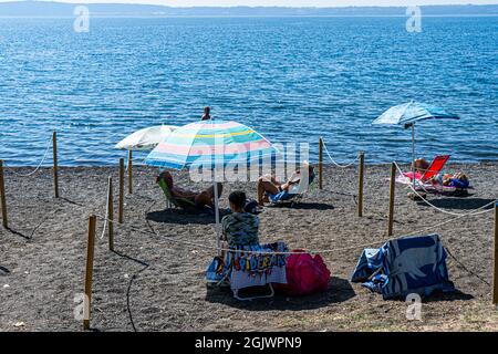 TREVIGNANO ROMANO ITALIEN, GROSSBRITANNIEN. 12. September 2021. An einem heißen Tag am Bracciano-See ist der Strand voll von Sonnenanbetern, da Familien und Menschen das Wochenende von Rom in den Ferienort Trevignano Romano verbringen, um die Sonne zu genießen, da die Temperaturen im September hoch bleiben. Kredit: amer ghazzal/Alamy Live Nachrichten Stockfoto