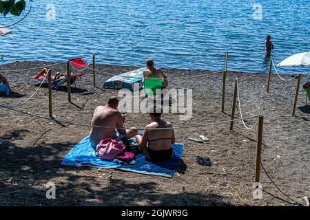 TREVIGNANO ROMANO ITALIEN, GROSSBRITANNIEN. 12. September 2021. An einem heißen Tag am Bracciano-See ist der Strand voll von Sonnenanbetern, da Familien und Menschen das Wochenende von Rom in den Ferienort Trevignano Romano verbringen, um die Sonne zu genießen, da die Temperaturen im September hoch bleiben. Kredit: amer ghazzal/Alamy Live Nachrichten Stockfoto