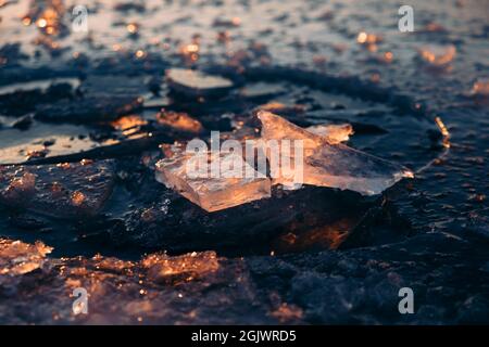 Gebrochenes Eis auf dem See in der Morgensonne. Eisstücke aus der Nähe. Stockfoto