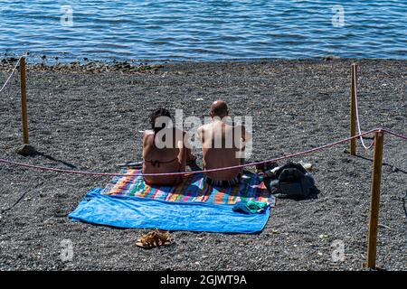 TREVIGNANO ROMANO ITALIEN, GROSSBRITANNIEN. 12. September 2021. An einem heißen Tag am Bracciano-See ist der Strand voll von Sonnenanbetern, da Familien und Menschen das Wochenende von Rom in den Ferienort Trevignano Romano verbringen, um die Sonne zu genießen, da die Temperaturen im September hoch bleiben. Kredit: amer ghazzal/Alamy Live Nachrichten Stockfoto