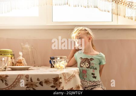 Porträt eines kleinen Mädchens Kleinkindes am Esstisch. Schlechter Appetit. Stockfoto