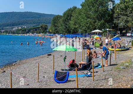 TREVIGNANO ROMANO ITALIEN, GROSSBRITANNIEN. 12. September 2021. An einem heißen Tag am Bracciano-See ist der Strand voll von Sonnenanbetern, da Familien und Menschen das Wochenende von Rom in den Ferienort Trevignano Romano verbringen, um die Sonne zu genießen, da die Temperaturen im September hoch bleiben. Kredit: amer ghazzal/Alamy Live Nachrichten Stockfoto