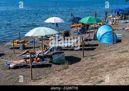 TREVIGNANO ROMANO ITALIEN, GROSSBRITANNIEN. 12. September 2021. An einem heißen Tag am Bracciano-See ist der Strand voll von Sonnenanbetern, da Familien und Menschen das Wochenende von Rom in den Ferienort Trevignano Romano verbringen, um die Sonne zu genießen, da die Temperaturen im September hoch bleiben. Kredit: amer ghazzal/Alamy Live Nachrichten Stockfoto