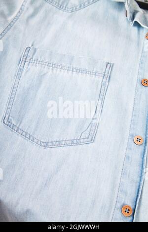 Hellblaues Denim-Hemd, Taschen- und Knopfdetail, blaues Jean-Hemd in Nahaufnahme Stockfoto