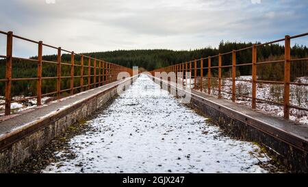 Ein schneebedeckter alter Eisenbahnviadukt am Big Water of Fleet am Cairnsmore, der in den Galloway Forest Park Dumfries und Galloway, Schottland, führt Stockfoto