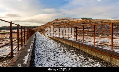 Ein schneebedeckter alter Eisenbahnviadukt am Big Water of Fleet im Cairnsmore des Fleet National Nature Reserve, Dumfries und Galloway, Schottland Stockfoto