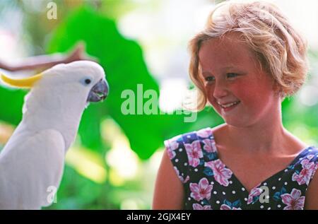 Australien. Junge Mädchen Kind Nahaufnahme mit Schwefel-Hauben Kakadu. Stockfoto