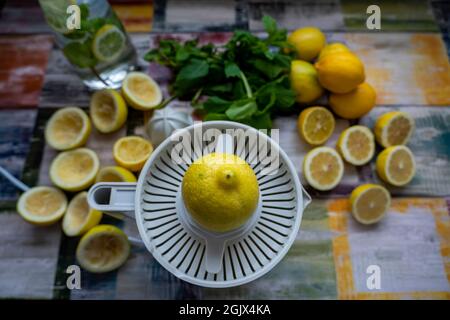 Draufsicht der Zubereitung von frischen Säften drücken Sie auf frische Zitrone und Limette. Zitrone Quetschmaschine oder Zitrone Presser. Stockfoto