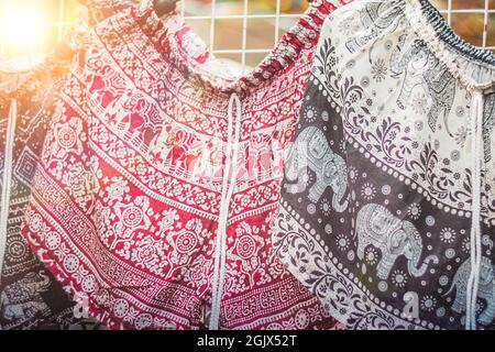 Kleidung hängt auf einem Regal in einem Flohmarkt Souvenir-Shop in Thailand Stockfoto