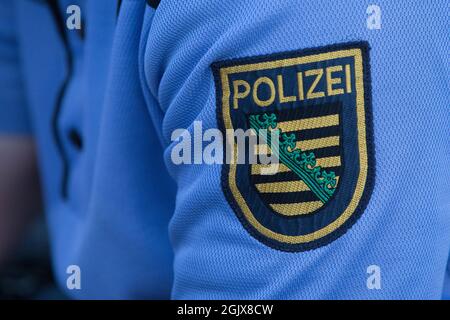 09. September 2021, Hamburg: Das Logo der sächsischen Polizei ist auf dem Hemd eines Polizeibeamten bei einem Großscheck auf dem Hamburger Fischmarkt zu sehen. Die Hamburger Polizei überprüfte mit Unterstützung von spezialisierten Polizeibeamten aus zehn Bundesländern, Österreich und der Schweiz sowie mit Unterstützung des Zolls im Rahmen der 15. DIS-Woche (Drug Detection in Road Traffic) zahlreiche Personen und Fahrzeuge. Foto: Bodo Marks/dpa/Bodo Marks Stockfoto