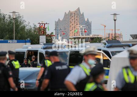 09. September 2021, Hamburg: Polizisten stehen bei einem Großscheck auf dem Hamburger Fischmarkt zusammen, im Hintergrund die Elbe-Philharmonie. Im Rahmen der 15. DIS-Woche (Drug Detection in Road Traffic) überprüfte die Hamburger Polizei mit Unterstützung spezialisierter Polizeibeamter aus zehn Bundesländern, Österreich und der Schweiz sowie mithilfe des Zolls zahlreiche Personen und Fahrzeuge. Foto: Bodo Marks/dpa/Bodo Marks Stockfoto