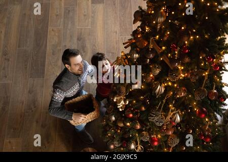 Oben über Ansicht glückliche Familie von zwei dekorieren Weihnachtsbaum. Stockfoto