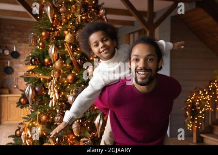 Portrait von glücklichem Biracial Vater und Sohn spielen an Weihnachten Stockfoto