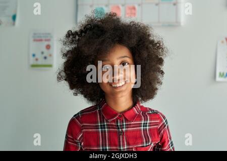 Porträt von niedlichen lächelnden afro amerikanischen Schulmädchen im Klassenzimmer stehen. Stockfoto