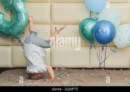 Ein Junge freut sich mit Konfetti und Luftballons über seinen Geburtstag Stockfoto