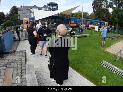 Wuppertal, Deutschland. September 2021. Auf einem Spielplatz stellen sich die Menschen in einem stillgefachten Eisenbahnwaggon für die erste Impfung gegen Corona an. Geimpfte können sich dort während der Sonderaktion ohne Registrierung impfen lassen. Quelle: Roberto Pfeil/dpa/Alamy Live News Stockfoto