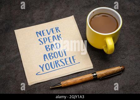 Sprechen Sie nie schlecht über sich selbst - inspirierende Handschrift auf einer Serviette mit einer Tasse Kaffee, Selbstachtung und persönlichem Entwicklungskonzept Stockfoto