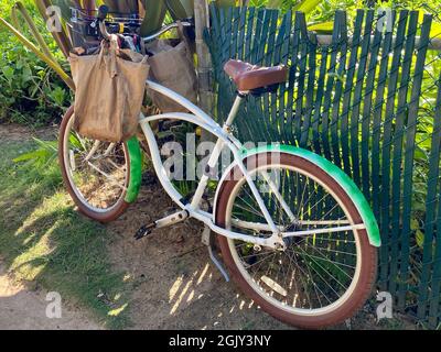 Das Cruiser-Fahrrad parkte entlang eines Zauns auf einem Strandweg in Hawaii Stockfoto