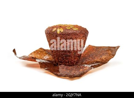 Goldener Muffin stehend mit flacher Oberseite auf Papiereinlage, Vorderansicht. Köstlicher, feuchter und flauschiger Morgenmuffin mit Karotten und Sonnenblumen Stockfoto