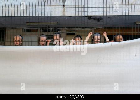 Ultra-orthodoxe Kinder blicken auf einen Zaun einer Schule im religiösen Viertel Geula. West Jerusalem Israel Stockfoto