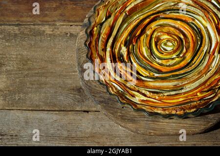 Gemüsekuchen mexikanische Sonne. Runde, offene Torte aus Zucchini, Auberginen und Karotten. Nahaufnahme von oben. Gesunde pflanzliche Lebensmittel. Vegetarismus. Spirale Stockfoto