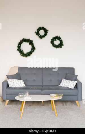 Skandinavisches Wohnzimmer mit Sofa und weihnachtsdekorationen Stockfoto