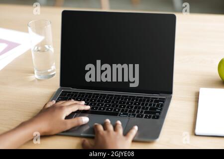Jugendliche unkenntlich schwarzes Mädchen auf Laptop mit leerem Bildschirm tippen und studieren Stockfoto
