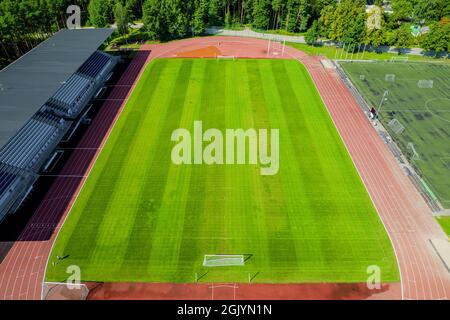 Luftaufnahme des grünen Fußballfeldes. Neues öffentliches Fußballstadion leer für Fußballspiele im Freien von oben. Schöner Fußballspielplatz als Hintergrundtextur-Konzept Stockfoto