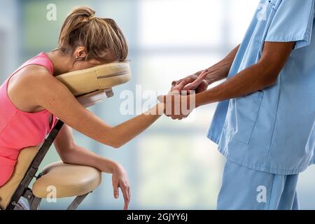Frau bekommt mobile Stuhl Massage von Mann im Büro Stockfoto