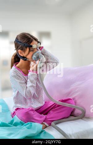 Kind, das an Schlafapnoe leidet, mit einem CPAP-Gerät Stockfoto