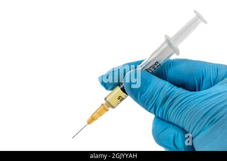 Hände mit Handschuhen, die eine Spritzendosis halten. Konzepte der medizinischen Behandlung, Epidemie oder Impfstoff Stockfoto