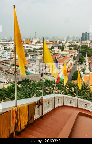 Panoramablick auf Bangkok vom Golden Mountain an bewölktem staubigen Tag, Thailand. Traditionelle thailändische Architektur von oben, moderne Wolkenkratzer im Hintergrund. Stockfoto