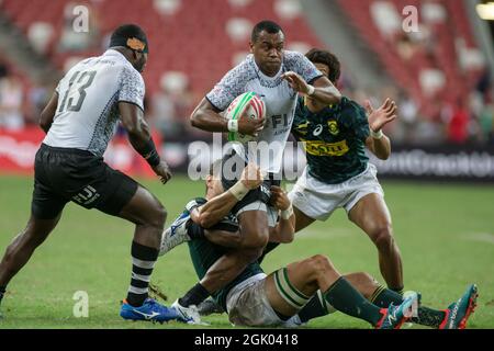 SINGAPUR-APRIL 14: Fidschi-7s-Team (weiß spielt gegen südafrikanische 7s-Team (grün) während des Cup-Finalspiels von HSBC World Rugby Singapore Sevens am 14. April 2019 im Nationalstadion in Singapur Stockfoto