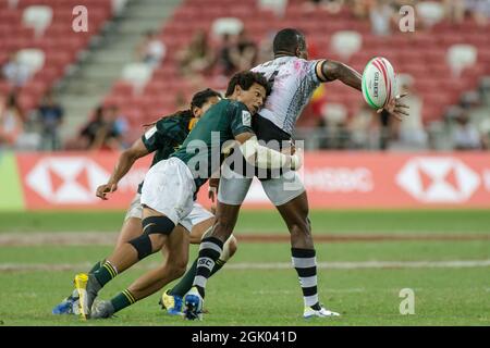 SINGAPUR-14. APRIL: Das südafrikanische 7er-Team (grün) spielt beim Cup-Finale von HSBC World Rugby Singapore Sevens am 14. April 2019 im Nationalstadion in Singapur gegen das fidschianische 7er-Team (weiß) Stockfoto