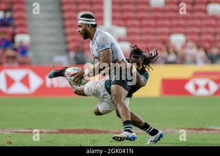 SINGAPUR-APRIL 14: Fidschi-7s-Team (weiß spielt gegen südafrikanische 7s-Team (grün) während des Cup-Finalspiels von HSBC World Rugby Singapore Sevens am 14. April 2019 im Nationalstadion in Singapur Stockfoto